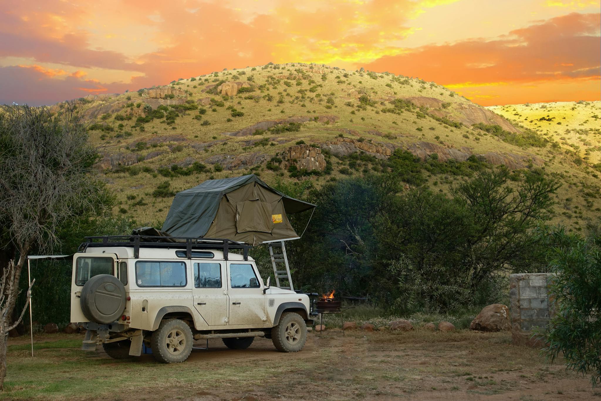 Land Rover with rooftop tent at sunset in the Bo-Karoo, South Africa, perfect for adventure travel.